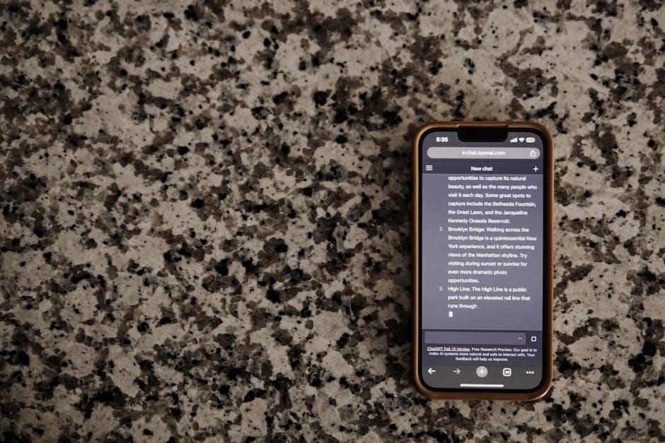 A smartphone displaying a chat app, placed on a granite countertop.