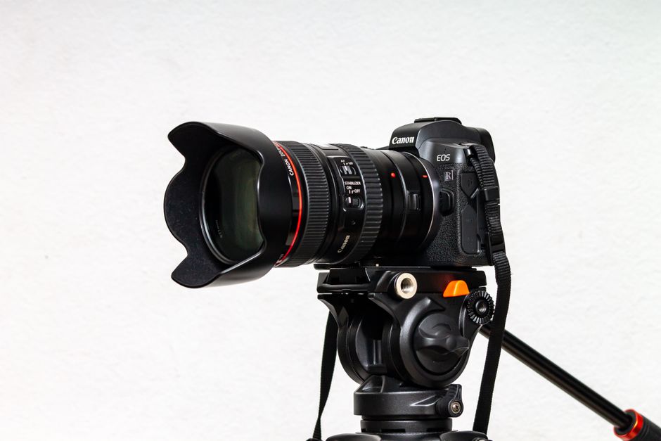 High-quality DSLR camera with lens mounted on a sturdy tripod, ideal for photography professionals.