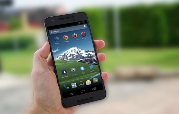 Close-up of a smartphone in hand displaying social media apps on screen.
