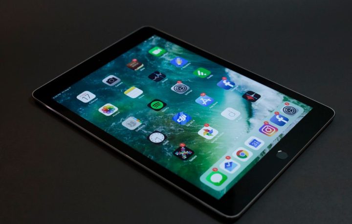 A sleek tablet with various multimedia and social media app icons on display.