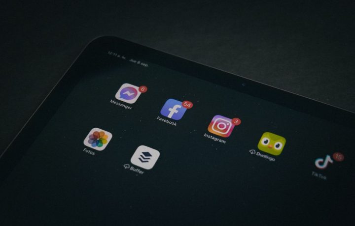 A tablet displaying popular apps like Facebook and Instagram in a dimly lit setting.