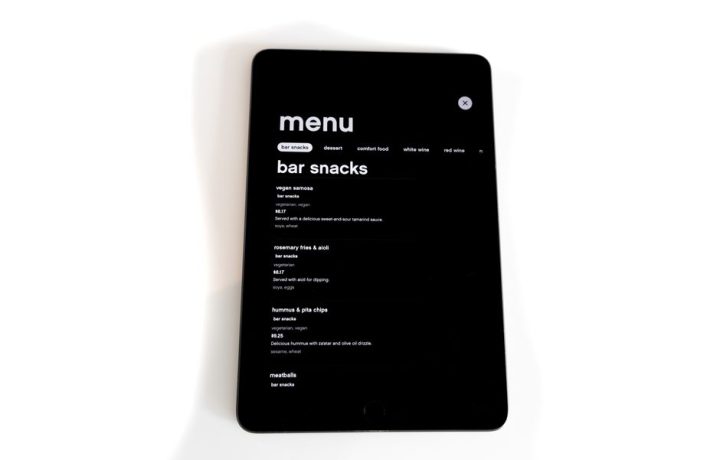 Tablet displaying a digital menu for bar snacks in a modern, minimalistic style.