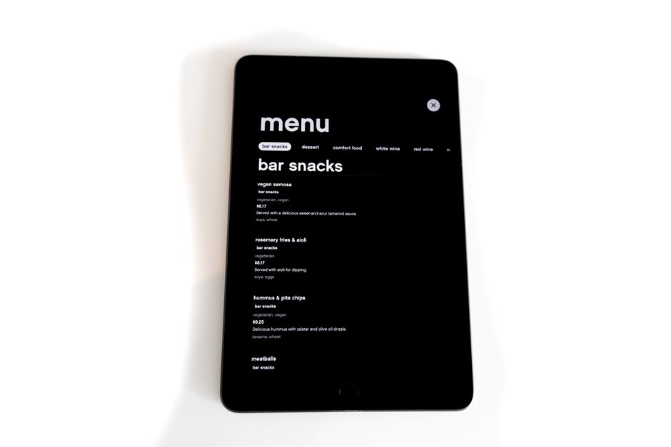 Tablet displaying a digital menu for bar snacks in a modern, minimalistic style.