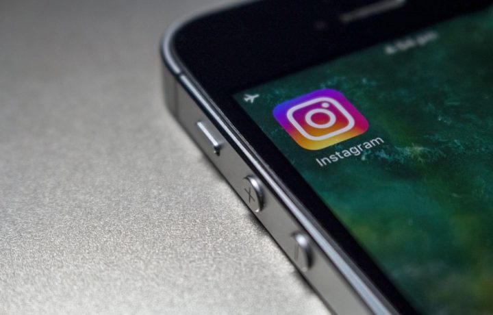Close-up image of a smartphone screen displaying the Instagram app icon, emphasizing modern technology.
