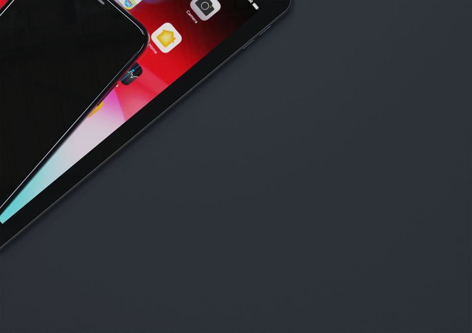 Top view of smartphone and tablet on dark gray surface with ample copyspace.