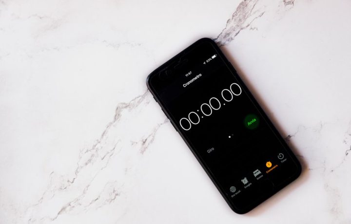 Close-up of a smartphone displaying a stopwatch on a marble surface.