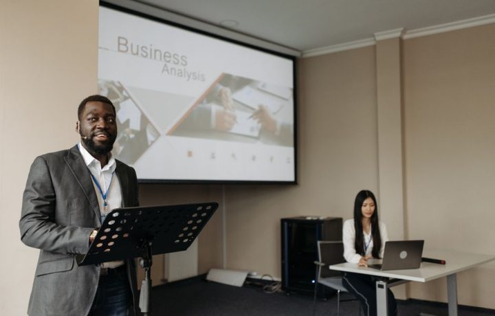 Business professionals presenting with projector and laptop in modern office.