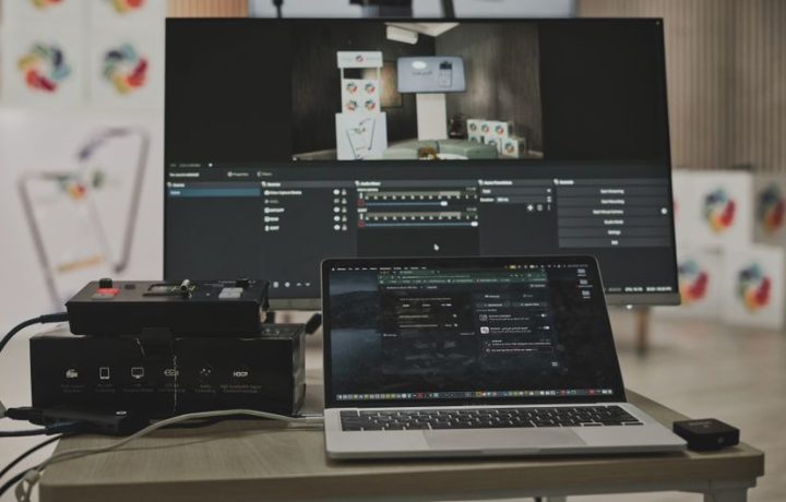 Multimedia setup featuring a laptop and a large monitor in a tech-savvy workspace.