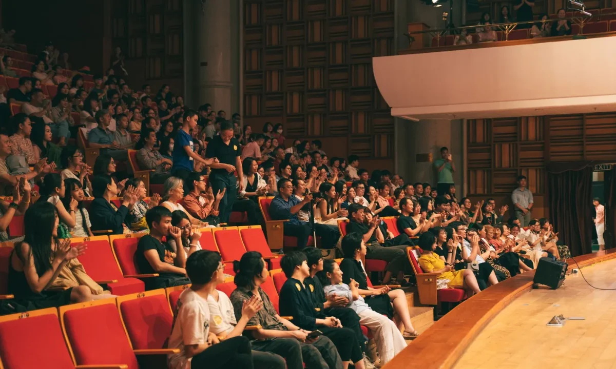 A lively audience applauding in a concert hall, showcasing the impact of audience engagement teleprompters