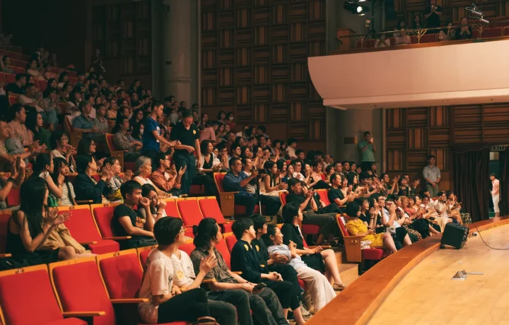 A lively audience applauding in a concert hall, showcasing the impact of audience engagement teleprompters