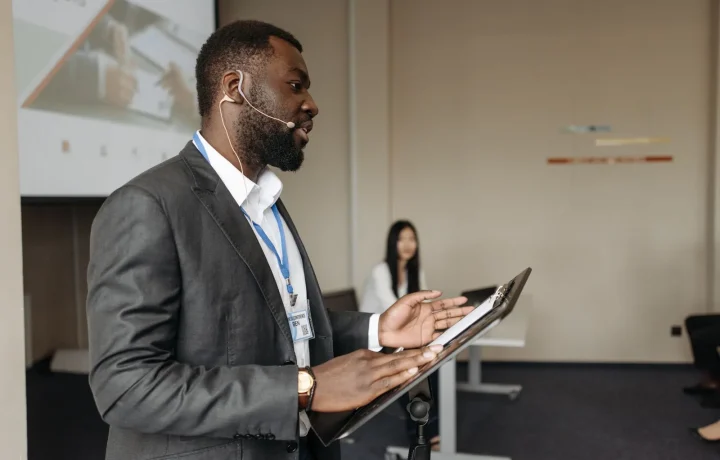 Confident speaker delivering a presentation using a teleprompter for presentations at a business conference