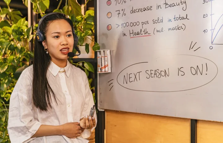 Engaging presenter using teleprompter tips for beginners while showcasing statistics on a whiteboard