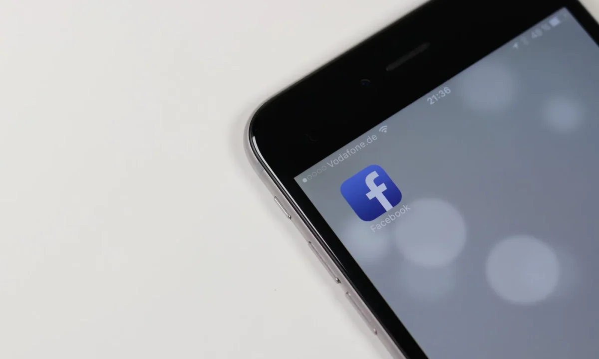 iPhone showcasing the best teleprompter apps against a blurred social media backdrop