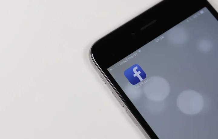 iPhone showcasing the best teleprompter apps against a blurred social media backdrop