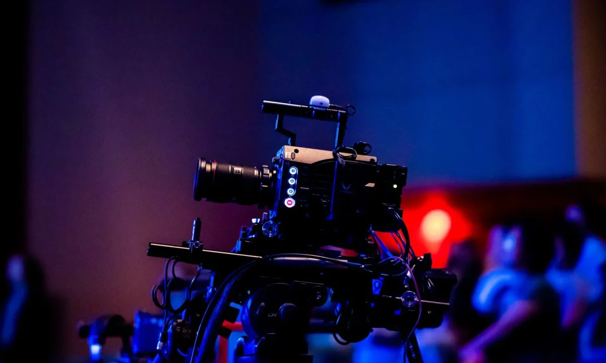 A high-quality camera setup in a studio capturing a live event with an engaged audience in the background