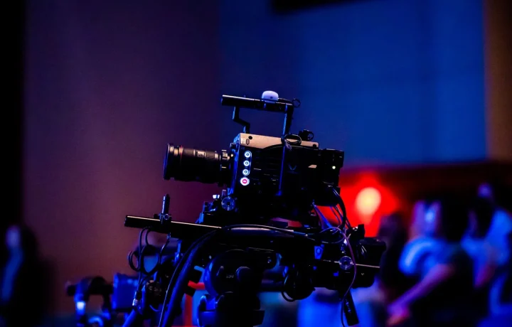 A high-quality camera setup in a studio capturing a live event with an engaged audience in the background