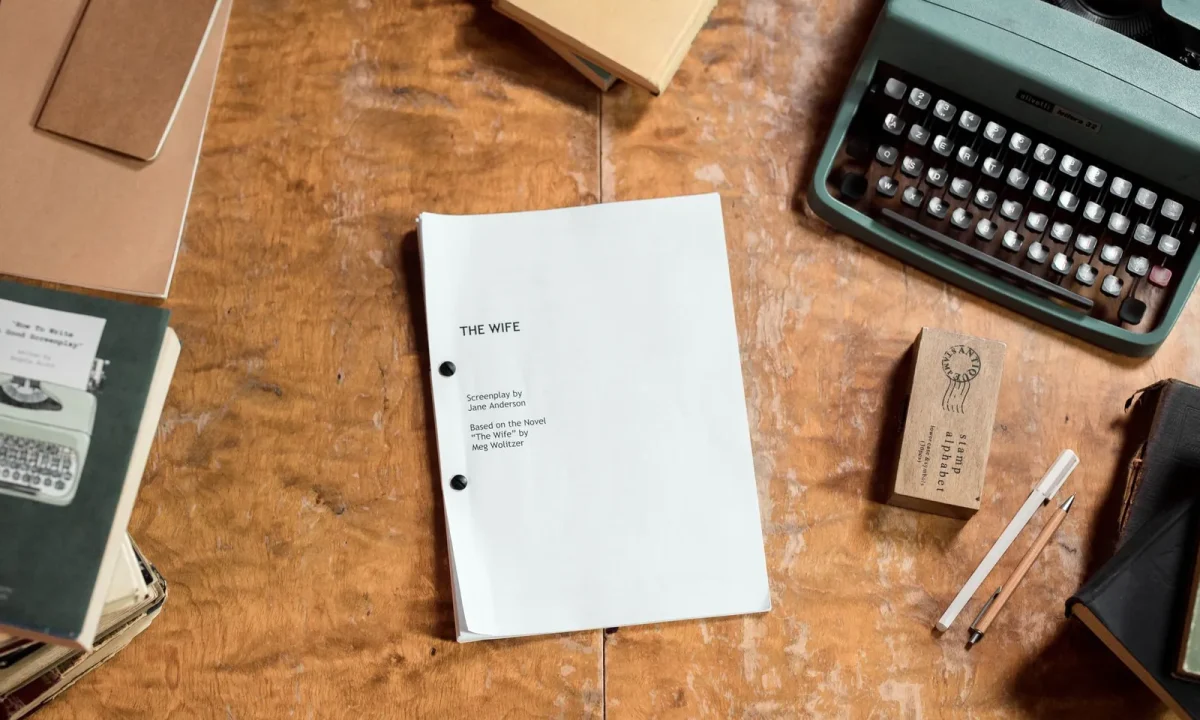 A retro-style desk with a typewriter and screenplay manuscript, illustrating script writing for teleprompters in action