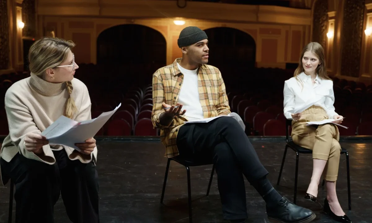 Actors rehearsing on stage with scripts, illustrating script writing for teleprompters and delivery practice