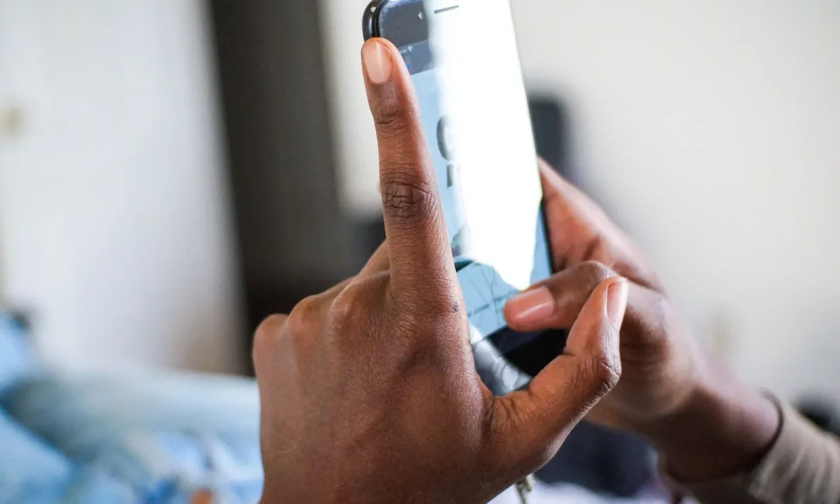 African American hand demonstrating a texting gesture on a smartphone, highlighting teleprompter app comparisons in use