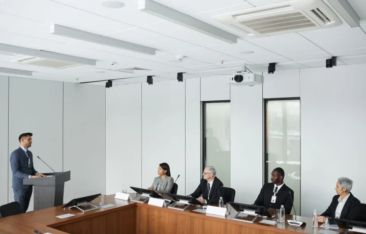 Business professionals collaborating in a modern conference room discussing the future of teleprompters