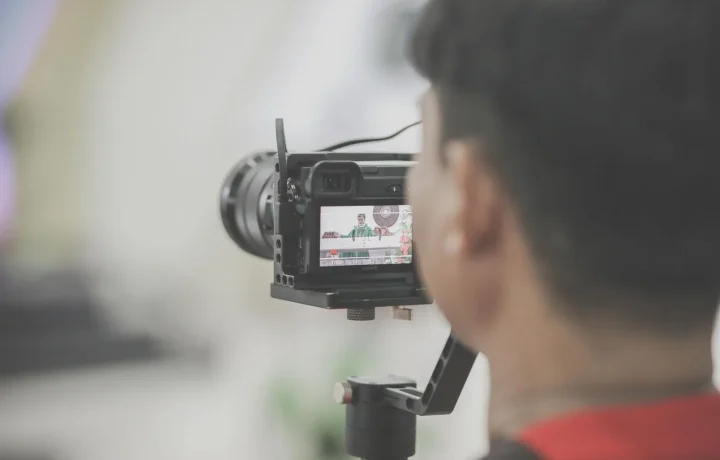 Close-up of a photographer using a professional camera setup to showcase the importance of choosing a teleprompter