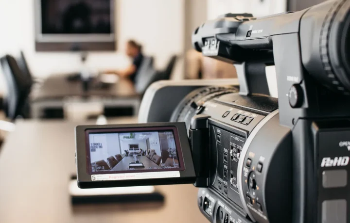 Close-up of a professional video camera recording in a modern office, illustrating the future of teleprompters