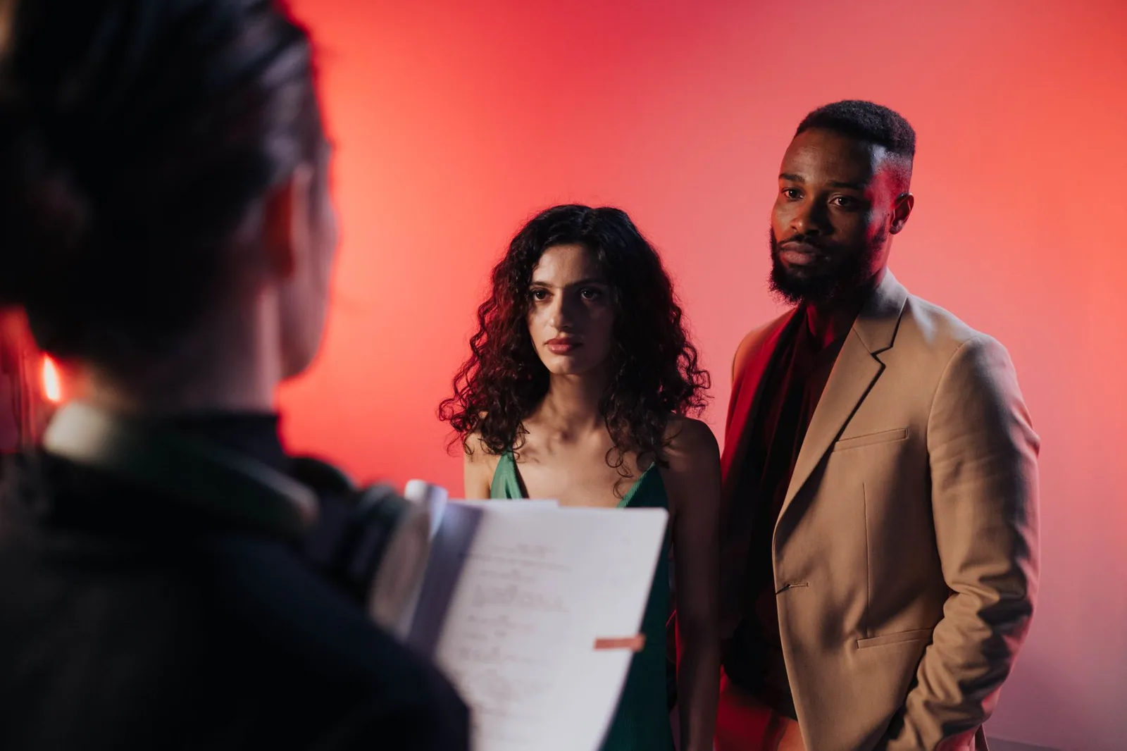 Couple reviewing their script together under warm studio lighting before production begins