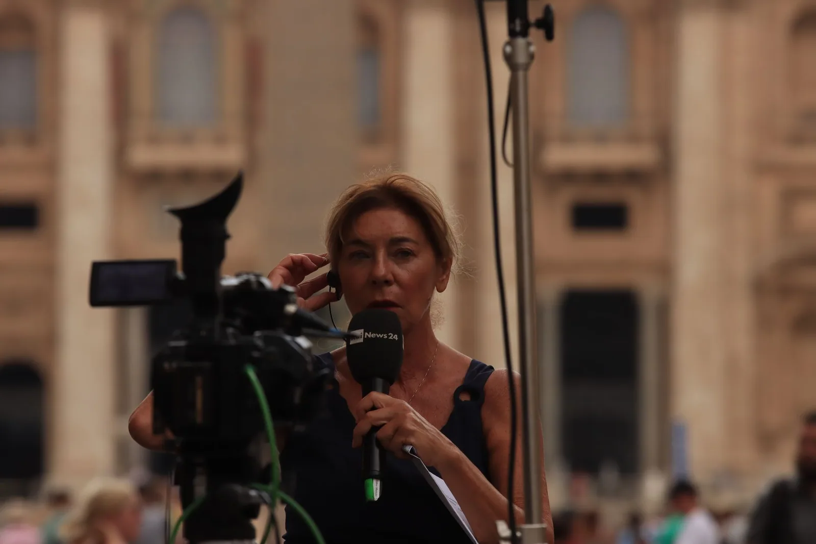 Journalist reporting live from Vatican City during a stand-up broadcast used to audit teleprompter workflow