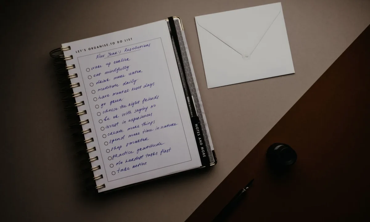Neat desk setup with to-do list, notebook, and envelope delivering essential tips for staying organized