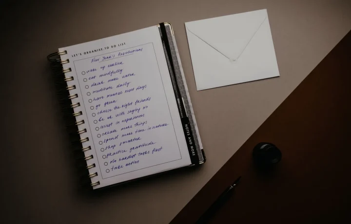 Neat desk setup with to-do list, notebook, and envelope delivering essential tips for staying organized