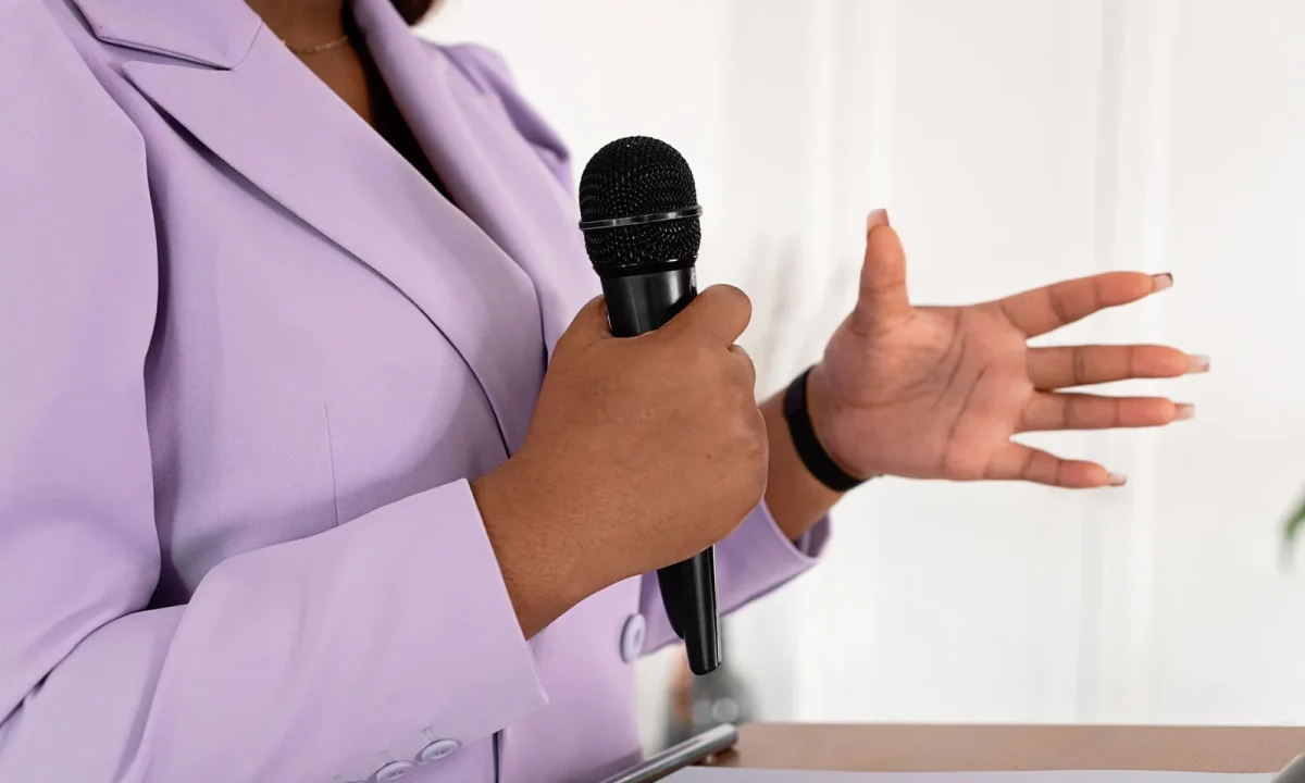 Presenter building on-camera confidence as she speaks into a microphone and gestures expressively