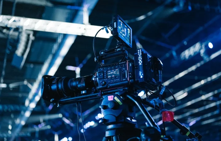 Professional video camera setup highlighting emerging teleprompter technologies in a bright indoor venue