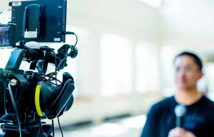 Professional video camera setup highlighting emerging teleprompter technologies with an interview scene in the background