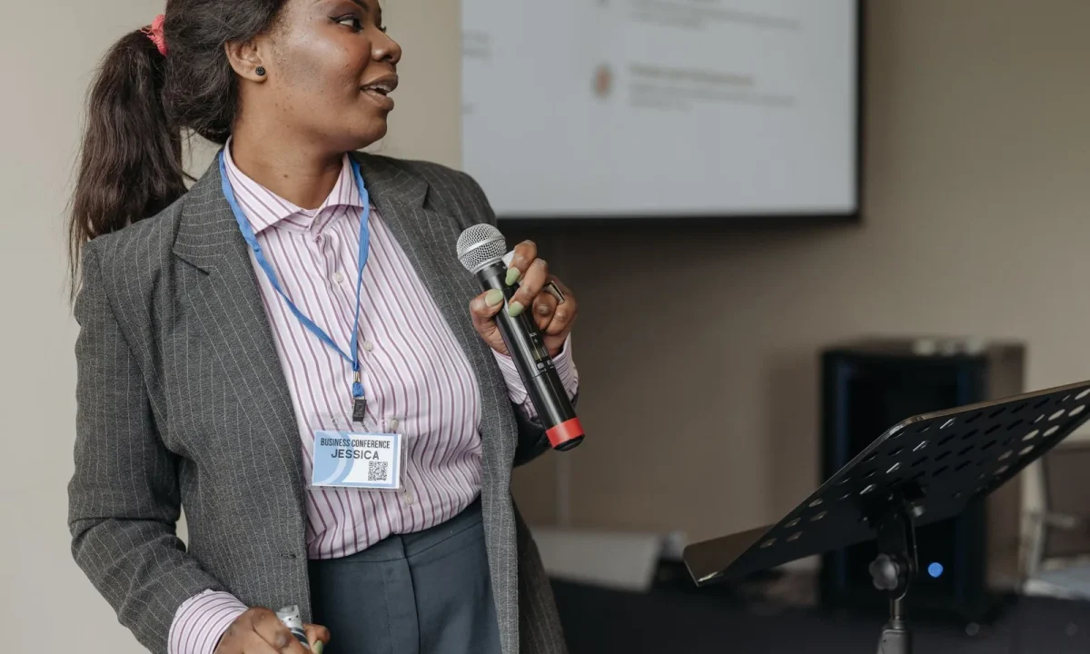 Professional woman presenting at a business seminar, effectively engaging audience with teleprompters