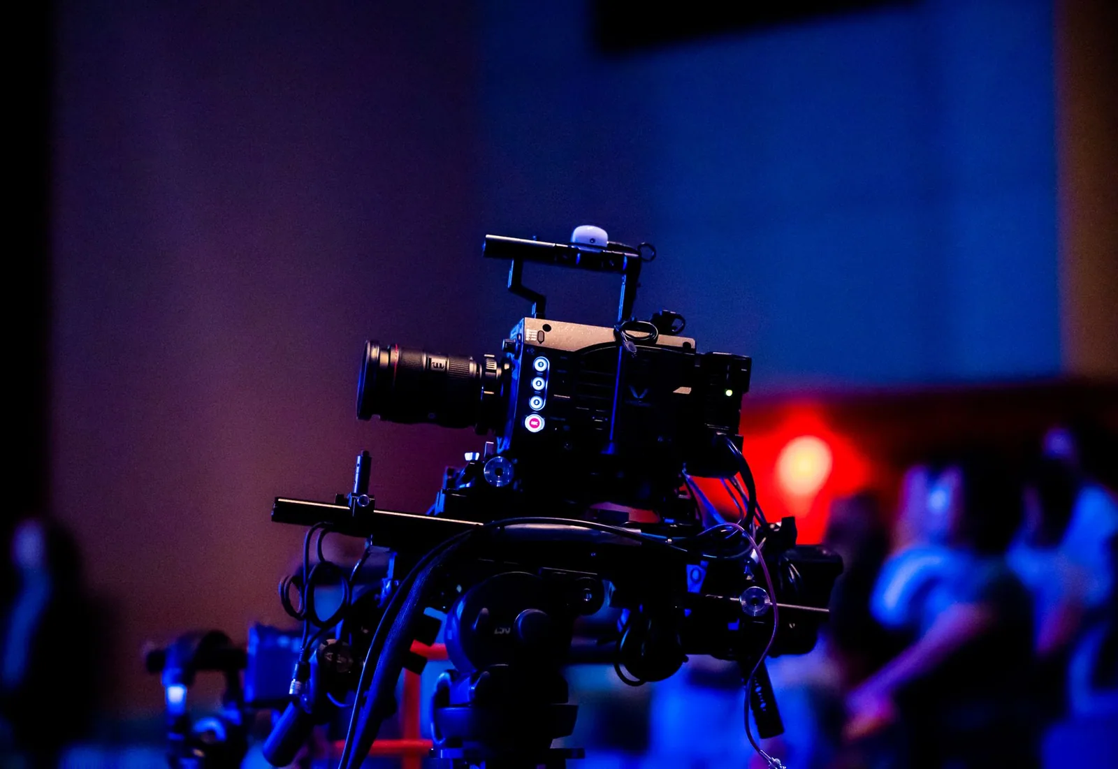 Studio camera recording a live event with an audience while the presenter reads through a prepared script