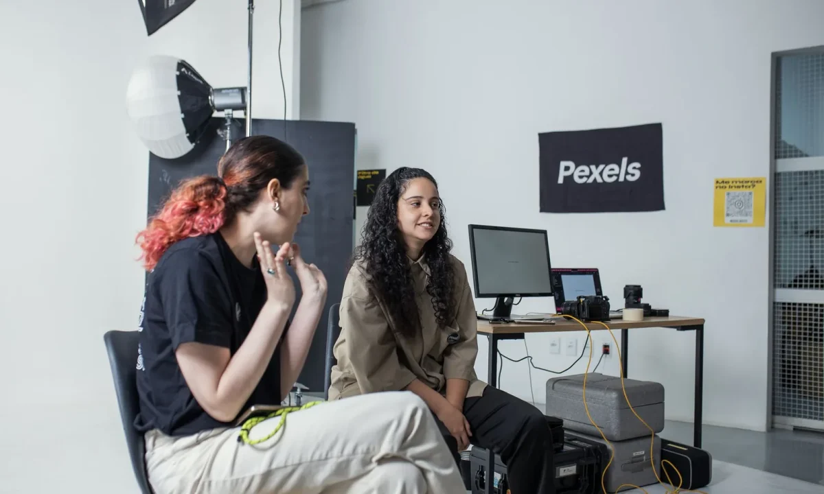 Two women collaborating amid studio gear, showcasing emerging teleprompter technologies in action