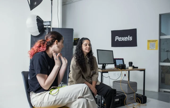 Two women collaborating amid studio gear, showcasing emerging teleprompter technologies in action